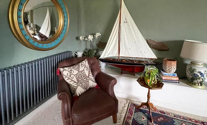 a leather chair with pond yacht in the corner of the snug at Ysgubor degwm seadog and stone self catering holiday.